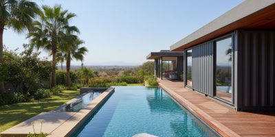 A sleek, modern container swimming pool with integrated decking, installed in a lush Kenyan backyard, showcasing IDEAL Contai